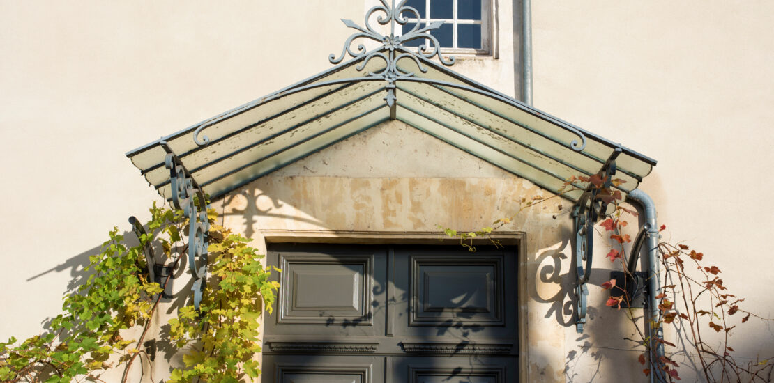 Un auvent de porte d'entrée pour protéger de la pluie, par Miroiterie Gardoise